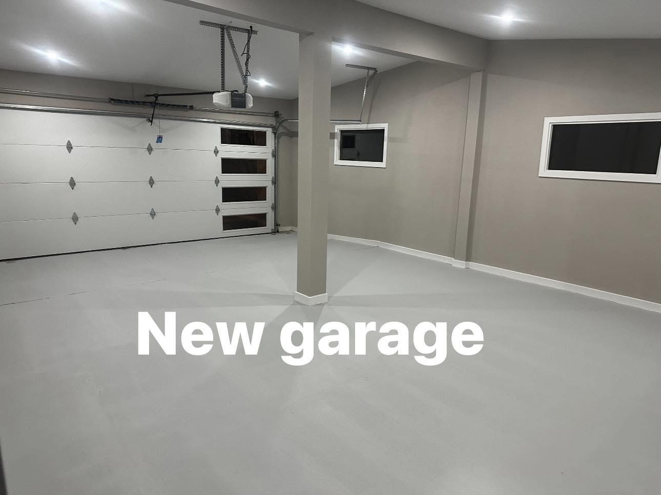Newly finished garage interior with drywall, lighting and clean concrete floor in East El Paso