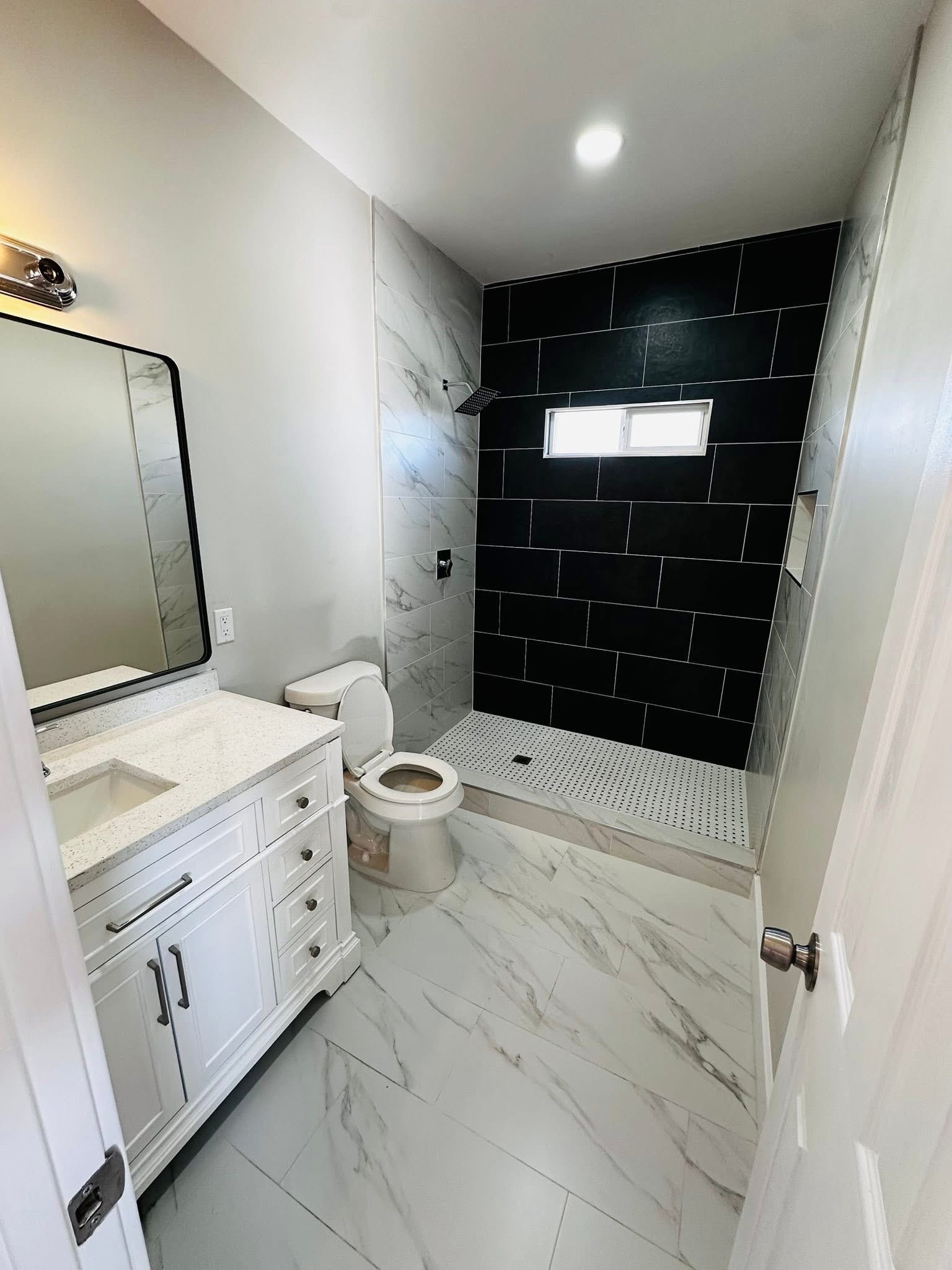 Renovated bathroom with curbless walk-in shower and marble tile in Horizon City