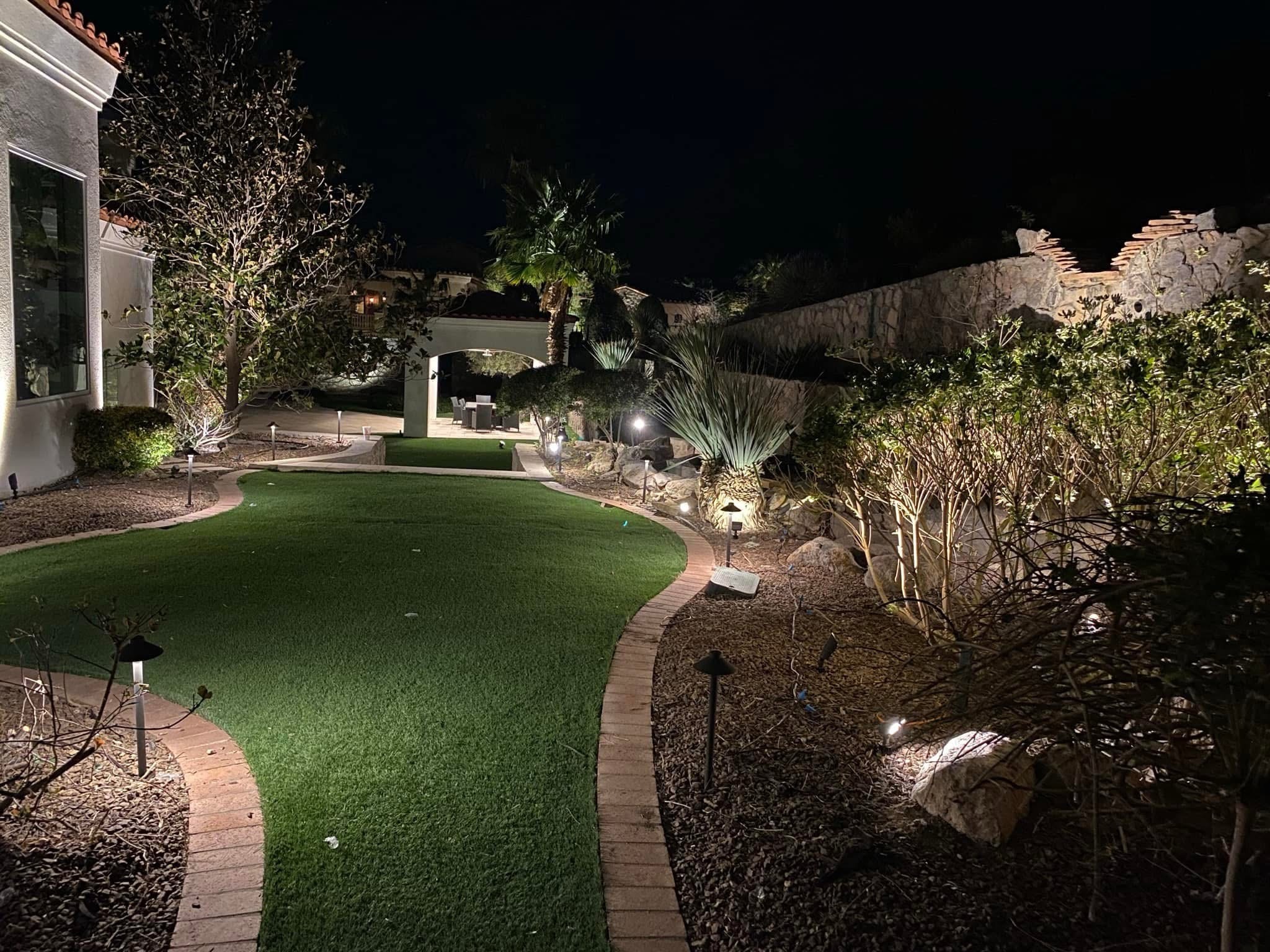 Backyard landscape lighting and turf installation at night in West El Paso